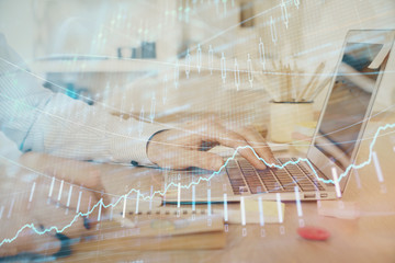 Multi exposure of stock market graph with man working on laptop on background. Concept of financial analysis.