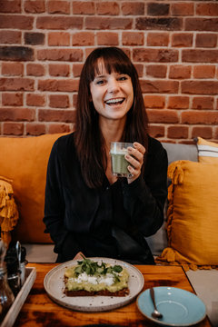 Frau mit Matche Tee lachend im Cafe