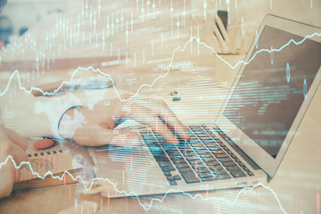 Double exposure of stock market graph with man working on laptop on background. Concept of financial analysis.