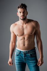 Fototapeta premium handsome sexy muscular man in jeans isolated on grey