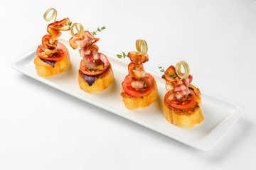 Snack canapes on a white glass plate. Catering service