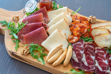 Sliced meat appetizer, meat dessert before lunch. Hamon sausages smoked products ham cheese and olives. Mediterranean food.