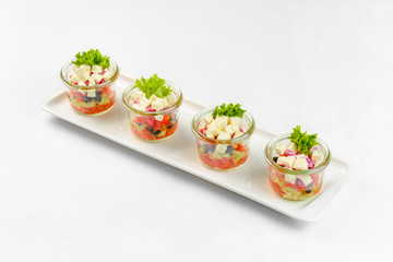 Appetizer vegetable salad in glass on white background. Catering service