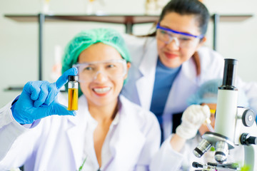 Close up on hands woman scientist pouring organic oil. Beauty and cosmetics sciences