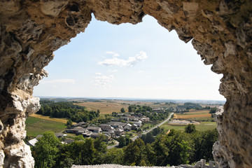 Countryside overview or small rural settlement as seen through a crenel in an old castle in Europe