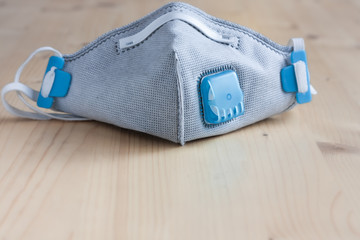 Respirator face mask with heavy-duty protective filter on a wooden light background. Madical face...