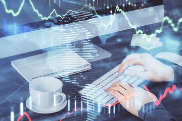 Multi exposure of graph with man typing on computer in office on background. Concept of hard work.