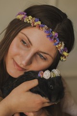  Portrait of young girl in floral wreath with Easter bunny. Easter background