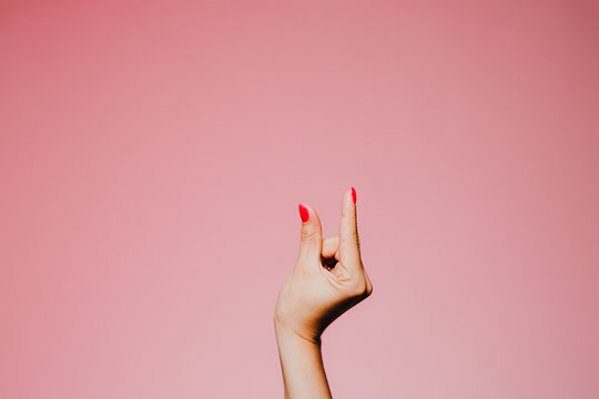 Woman's hands with bright manicure isolated on pink background small size gesture