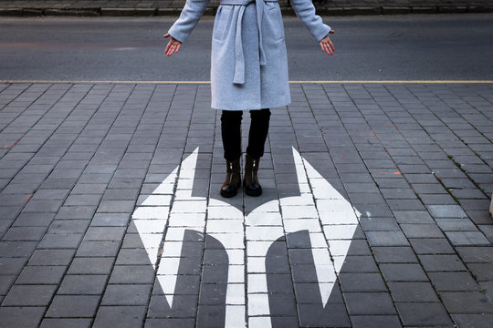 Make choice which way to go. Decision concept with directional arrow sign and woman standing at road