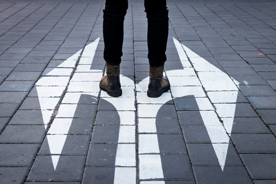 Make Decision Which Way To Go. Walking At Directional Sign On Road