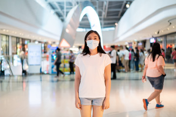 Woman wearing a hygiene protective mask to protect COVID19 virus, COVID-19 and pm2.5 while traveling in the crowded place. Woman use face mask to protect coronavirus disease. 2019-nCov crisis.