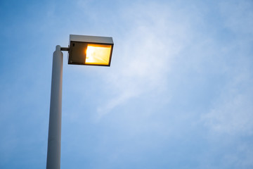 Street illuminating light post during the twilight sky close up with copy space.