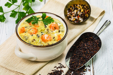 Homemade Fresh Creamy Soup with Chicken, Carrot, Vegetables and Wild Rice. Selective focus.