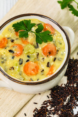 Homemade Fresh Creamy Soup with Chicken, Carrot, Vegetables and Wild Rice. Selective focus.
