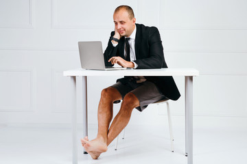 Happy businessman in suit using laptop in office