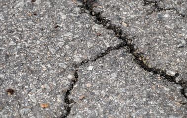 Time for road repair when the pavement begins to crack and crumble, Bokeh effect.