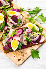 Beetroot and Pickled Marinated Herring Open Sandwich on Rye Bread. Selective focus.