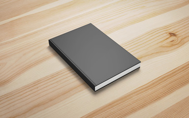 Book with blank black hardcover on wooden desk background as template for your design presentation, promotion etc.