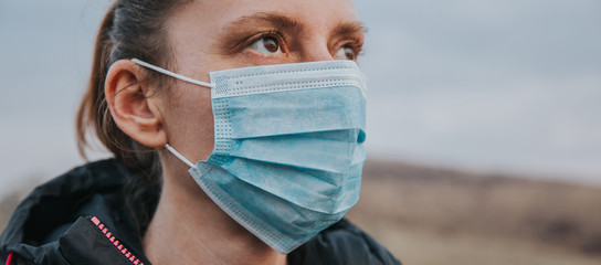 Woman wearing surgical mask outdoors to prevent Covid-19. 