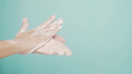 Close up of Asian women Cleaning hands with white soap bubbles on blue background. Hand washing demonstration for virus protection. Concepts of hygiene and prevention of covid 19
