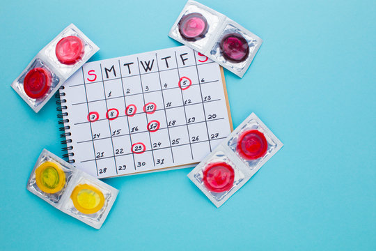 colored condoms and calendar on a blue background
