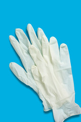 Fototapeta na wymiar Two light hygiene gloves on a blue background. Top view. Vertical orientation