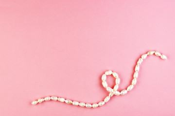 women's jewelry made of pearls. white beaded bracelet on a pink background. pastel background for women's day
