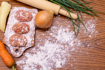 Cutlets lie on the board sprinkled with flour