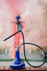 Hookah outdoors on a background of colored smoke