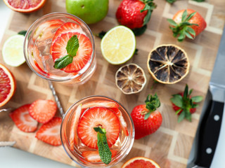 Glass poured cocktail with slices strawberries