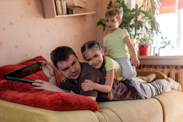 Happy man with children using laptop and earphone during his home working, life in quarantine