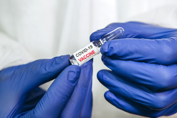 the doctor is holding a test tube with a coronavirus vaccine on a white background. Vaccine...