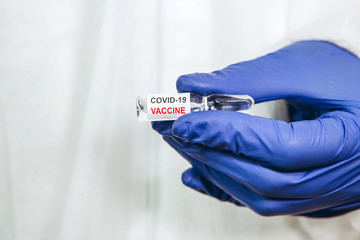 the doctor is holding a test tube with a coronavirus vaccine on a white background. Vaccine...