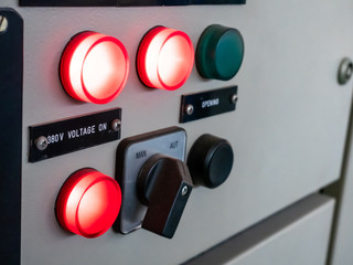 industrial control panel with switch and red lights on