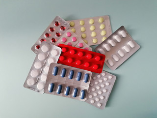 Tablets in a blister pack on a textured color background, copy-space.