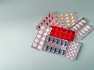 Tablets in a blister pack on a textured color background, copy-space.
