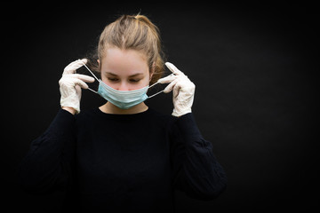 une jeune femme blonde est en train de se mettre un masque de protection sur le  visage