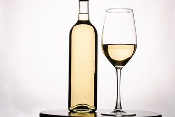 Bottle of delicious wine and glass on white background