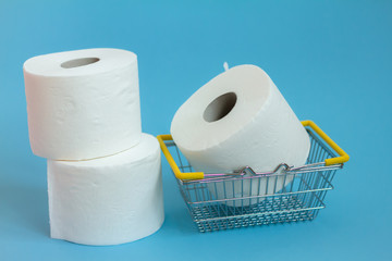 Toilet paper in shopping cart on blue background. shortage concept. Coronavirus. panic concept . Hygiene toilet 