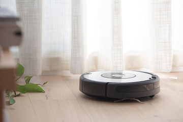 robot vacuum cleaner loading cleaning a wooden floor