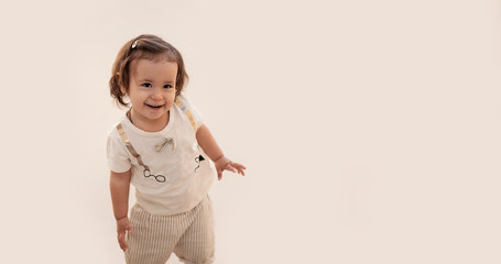 Happy and joyful baby girl posing on a light background. Emotional children. Knowledge of the world in travel. Banner.