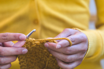 Woman crochets a hat.