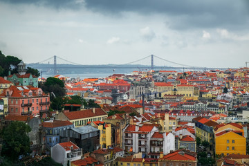Fototapeta na wymiar Lisbon from a terrace. All the rooftops from above and the 25 de Abril bridge at the back.