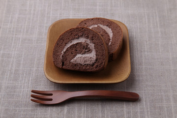 お皿にのせた チョコレート ロールケーキ テーブル