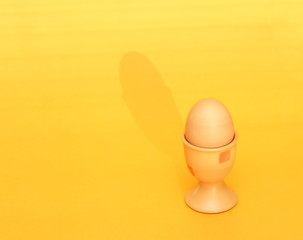 egg in cup on yellow background