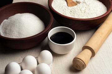 harina huevos azucar y escencia de vainilla harina volando y cayendo sobre cuenco de madera listo para amazar