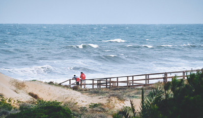 two beach watchers watching the sea with waves
