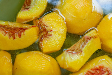Peach slices in a bowl of water