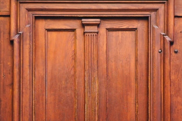 Fototapeta na wymiar Antique luxury wooden door surrounded by handmade decor and carvings. Mahogany, portal to an ancient building.